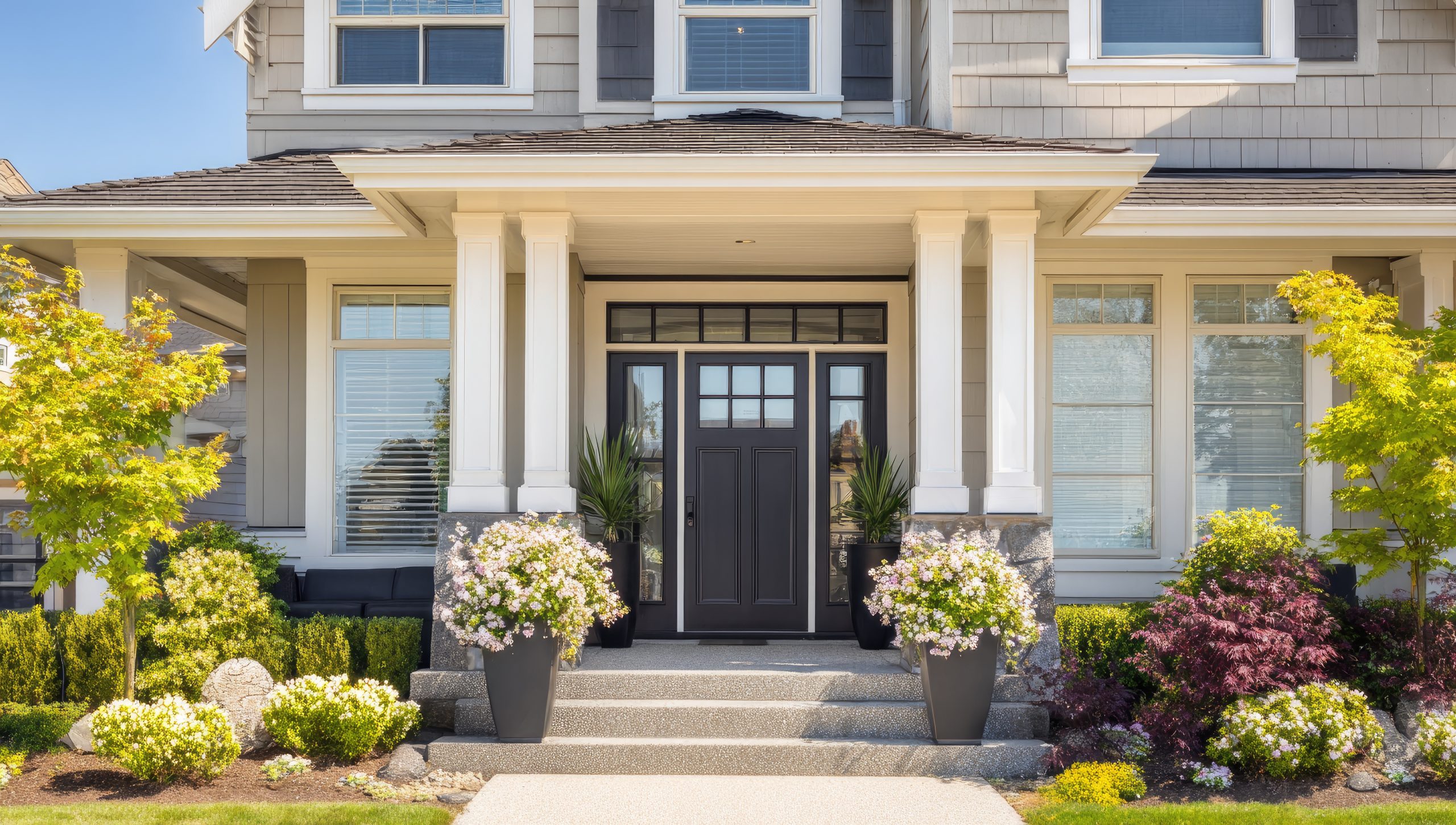 Front porch of a house with dark door and landscaping