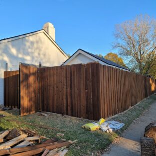 A brown fence wrapped around a house