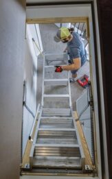 Handyman folding up attic ladder