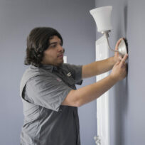 Handyman installing light fixture