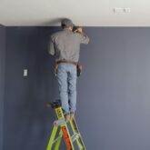Handyman Painting top of a wall