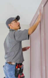 Handyman filling wholes in accent wall