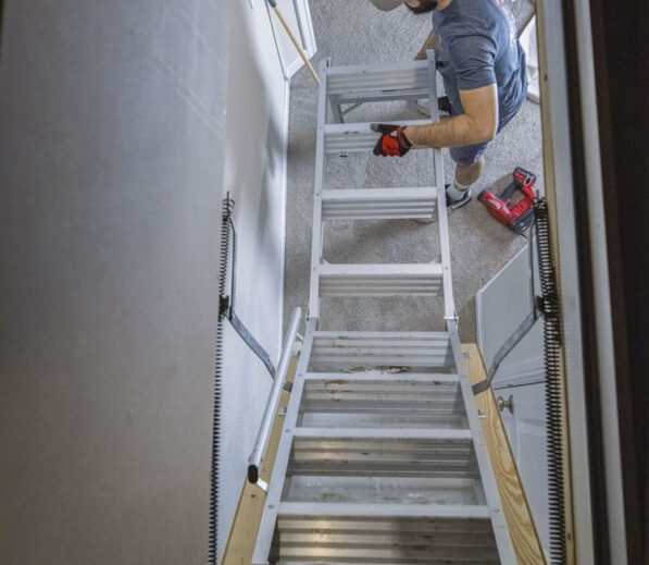 Handyman Installing an attic ladder in a home