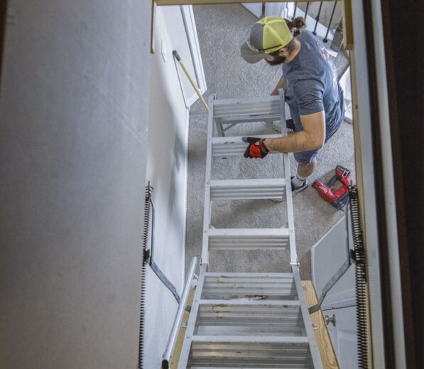 Handyman Installing an attic ladder in a home